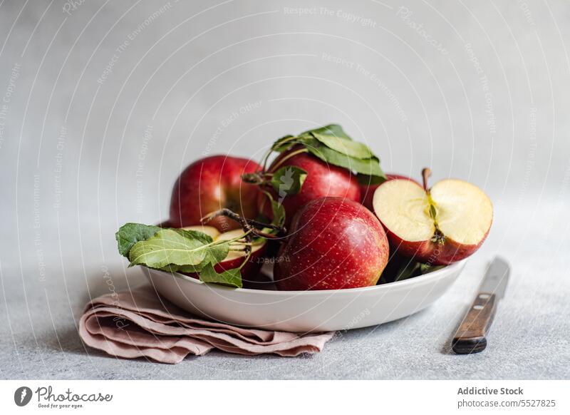 Fresh apples in plate on gray surface knife fruit ripe cloth vitamin fresh bunch organic natural food healthy delicious nutrition vegetarian edible vegan
