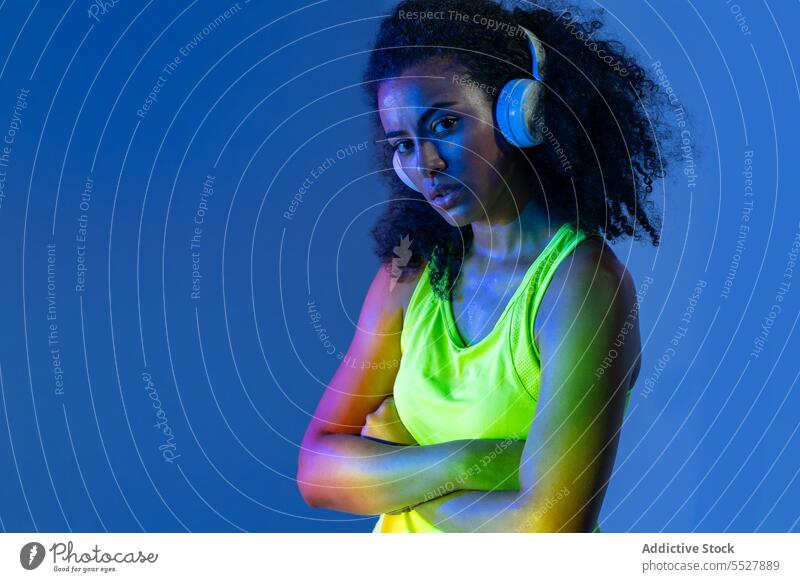 Black woman in headphones standing studio shot sport listen music fitness audio melody black female sportswoman meloman ethnic sound activewear wellness