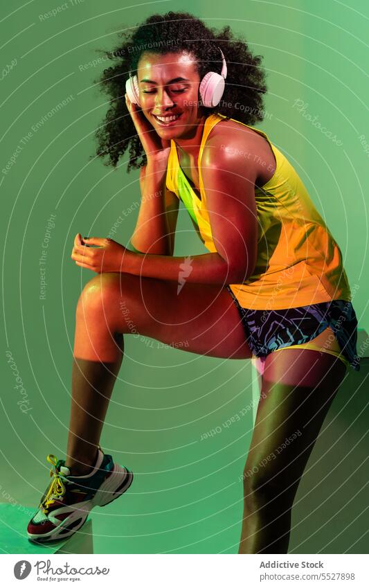 Alluring ethnic female in activewear woman headphones studio shot sport listen music fitness black audio melody sportswoman african american meloman sound