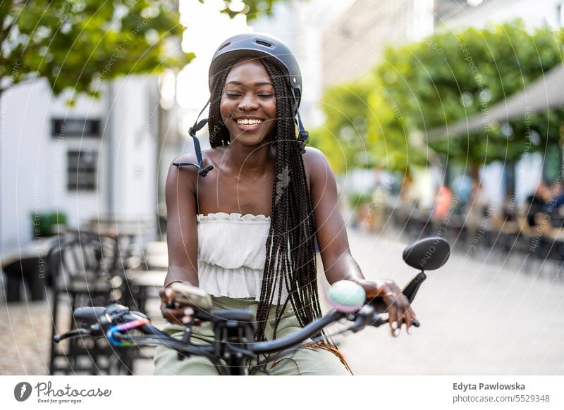 Portrait of an young woman with her bicycle in the city adult attractive beautiful black confidence confident cool female girl hairstyle leisure lifestyle
