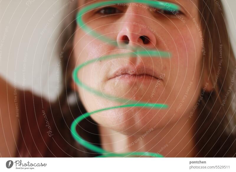 a green spiral in front of a woman's face. thought spiral Face Woman Movement Toys Green Spiral Joy Mouth Dynamics Round Demanding concentrated Pride game