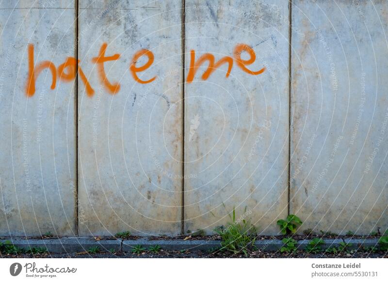 Graffiti 'hate me' on concrete wall. Concrete wall Gray lettering Anger Aggression Characters Emotions Wall (barrier) Rebellious Wall (building) Animosity