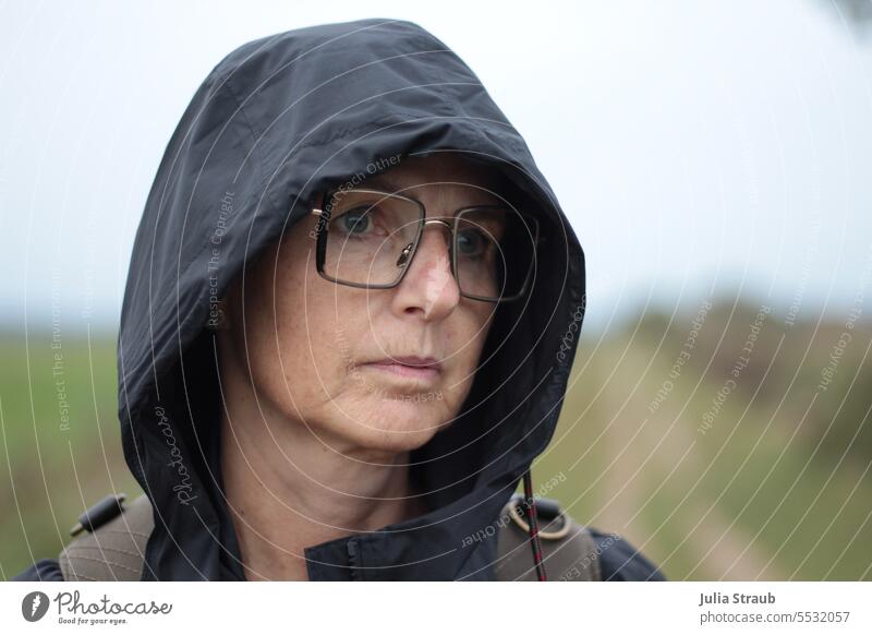 Wide land | Mother Mary ;) Woman Rain jacket Hooded (clothing) Eyeglasses Backpack Rainy weather melancholy Meditative on one's own Loneliness Concern Pensive