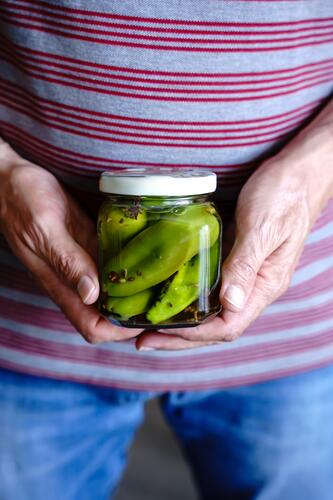 A man with a jar of pickled peppers. Close up. Preserving jar Pepper Vinegar Close-up hands Man stop Vegetable Nutrition Colour photo Healthy Eating