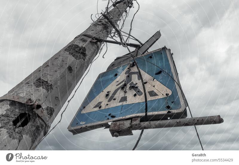 concrete pillar broken by shards and a road sign against a gloomy sky Donetsk Kherson Kyiv Lugansk Mariupol Russia Ukraine Zaporozhye abandon abandoned attack