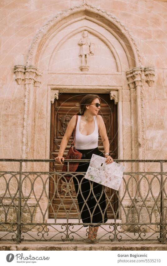 Female tourist with city map by the church San Francesco d’Assisi in Ostuni, Italy woman female paper navigation direction tourism summer view ostuni cityscape