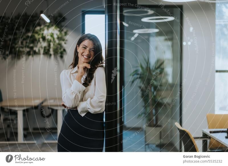 Young business woman standing with arms crossed in the modern office employee businesswoman manager portrait leader professional executive female smiling work