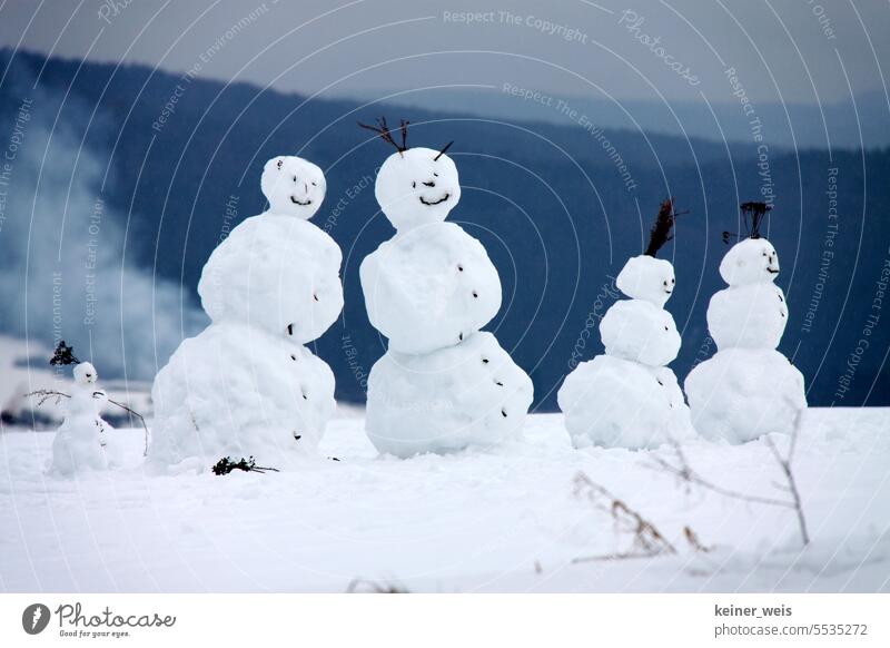 Snow woman and snowman with their snow children as an idyllic family picture of the snowman family in winter snow woman Snowman Snowman family Family