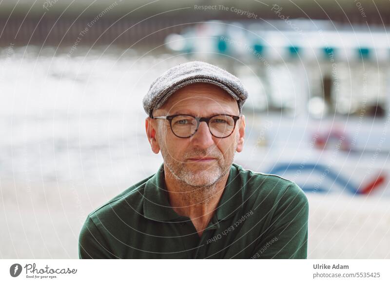 Wide land|fixing view Cap portrait Exterior shot Face Looking Facial hair Head Human being Man Adults Eyeglasses naturally Person wearing glasses