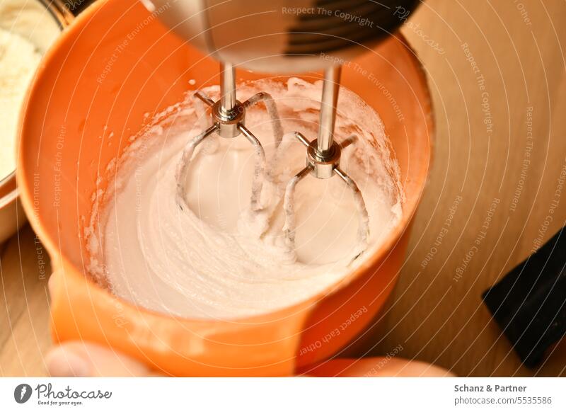 Whipped egg whites or cream is whipped with a mixer in an orange mixing bowl Baking Prepare Kitchen boil Stir Whisk Dough Preparation Ingredients