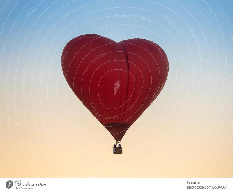 Hot Air Balloon in Red Heart Shape at sunset sky background hot-air balloons heart heart shape balloon flights hot air balloon dawn balloon flights sunrise