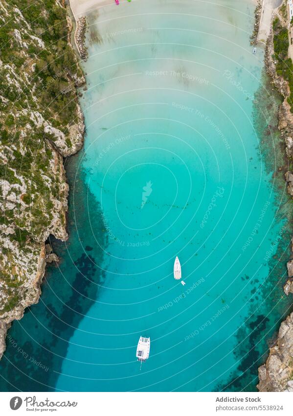 Drone view of clear sea water with moored boat sailboat ocean float turquoise island nature paradise vessel surface seascape marine transparent menorca