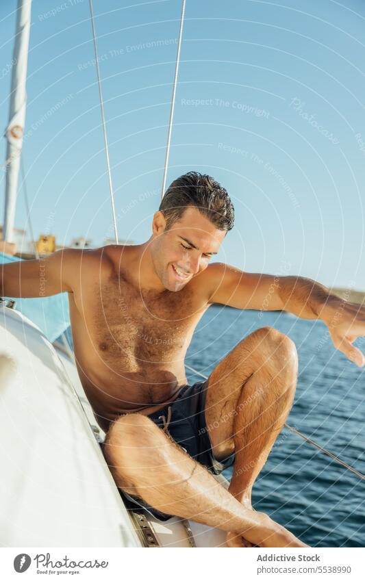 Handsome man on sailboat in the ocean yacht sensual summer vacation confident sensuality cruise happy body dreamer stylish smile vessel model outdoors male