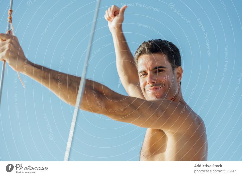 Handsome man on sailboat in the ocean yacht sensual summer vacation confident sensuality cruise smile body dreamer stylish vessel model outdoors happy male
