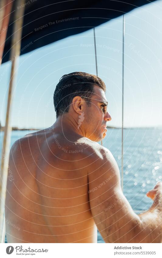 Handsome man on sailboat in the ocean yacht sensual summer vacation confident sensuality cruise body dreamer stylish vessel model outdoors male natural fit