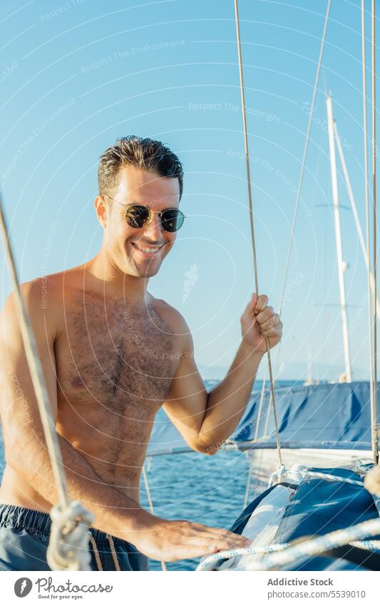 Happy handsome man on sailboat in the ocean yacht smile summer vacation confident cruise happy body dreamer stylish vessel model outdoors male natural fit