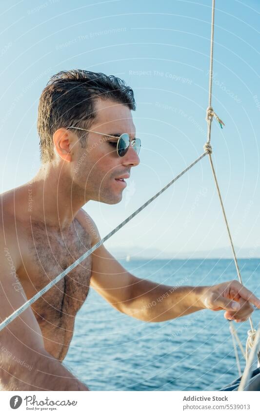 Handsome man on sailboat in the ocean yacht sensual summer vacation confident sensuality cruise body dreamer stylish vessel model outdoors male natural fit