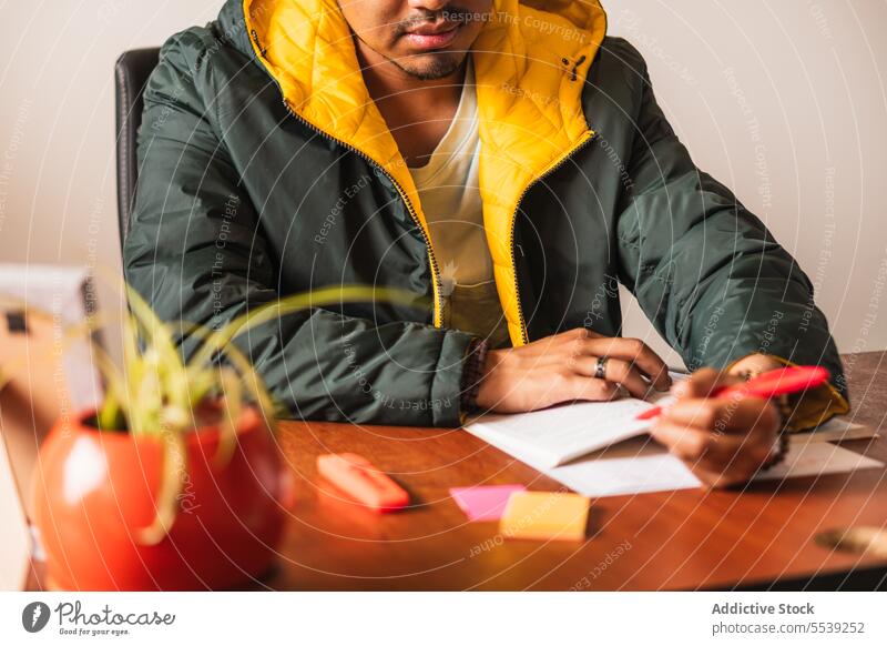 Serious man taking notes in notebook take note freelance work remote write notepad focus male ethnic project home thoughtful concentrate sit professional job