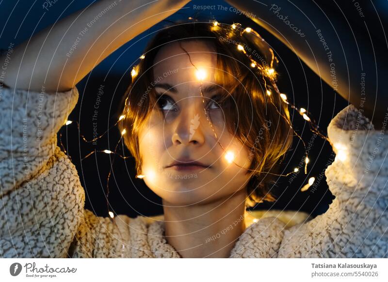 Portrait of a short-haired woman with lights on head string Illuminated Tangled Night Dark Evening electric Short Hair christmas lights fairy lights
