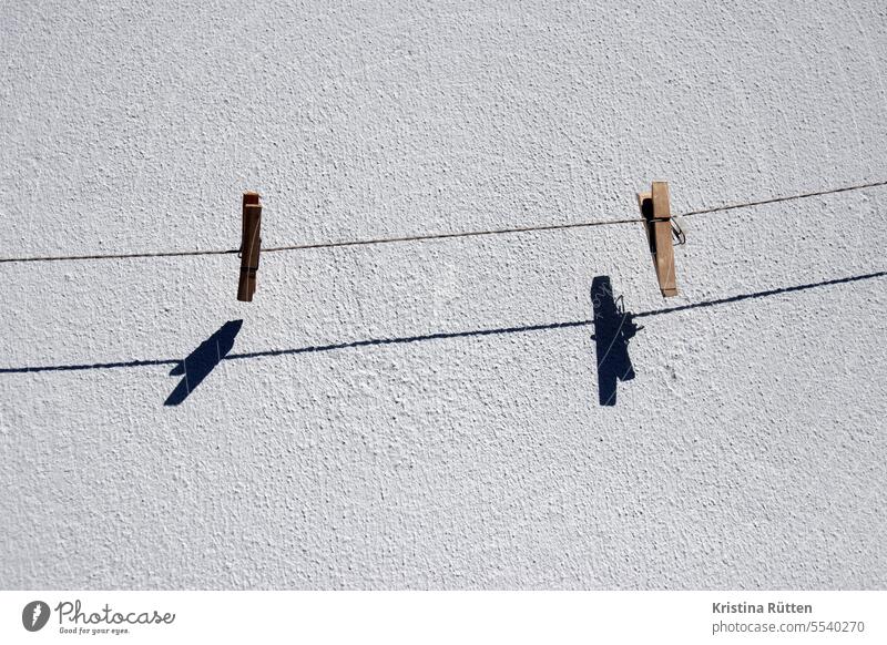 parallel world | wood clips in sunlight clothespin wooden staples two clothesline Shadow leash Hang up Attach Dry Household everyday life Washing day sunny