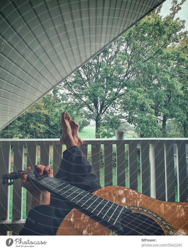 singer-songwriter Guitar acoustic guitar Legs crossed Balcony Playing Feet top raise one's feet chill Vantage point House (Residential Structure) terrace Tree