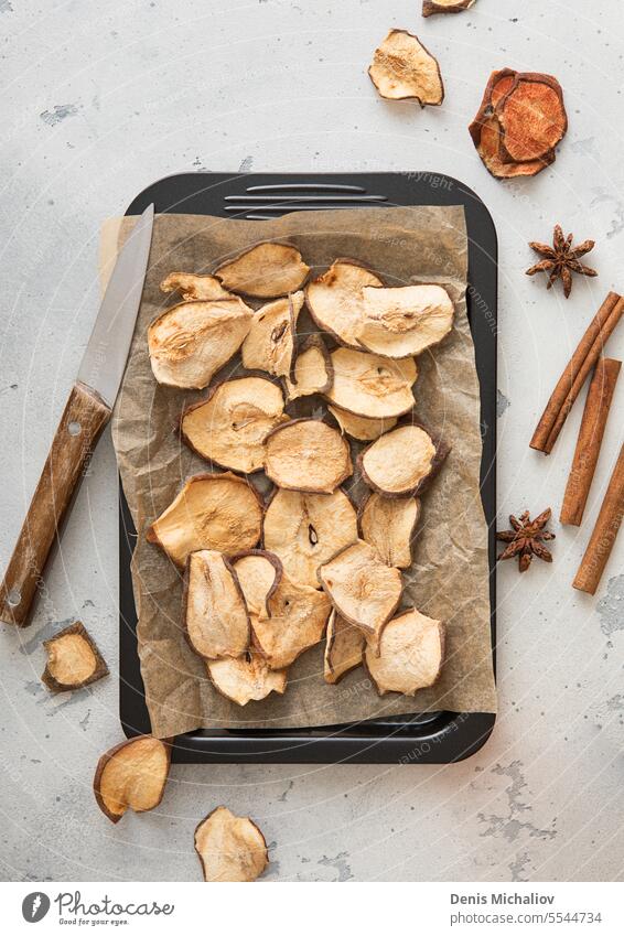 Dried pear slices on baking tray with cinnamon on light table.Macro. dried fruit healthy organic diet vegetarian food vitamin dry natural ingredient sweet