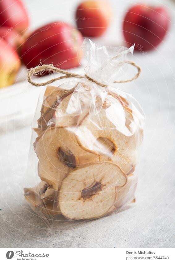 Organic dried apple rings in clear package and red ripe apples in box.Macro. dry snack healthy organic chip sweet tray baking fruit vegetarian fiber diet food