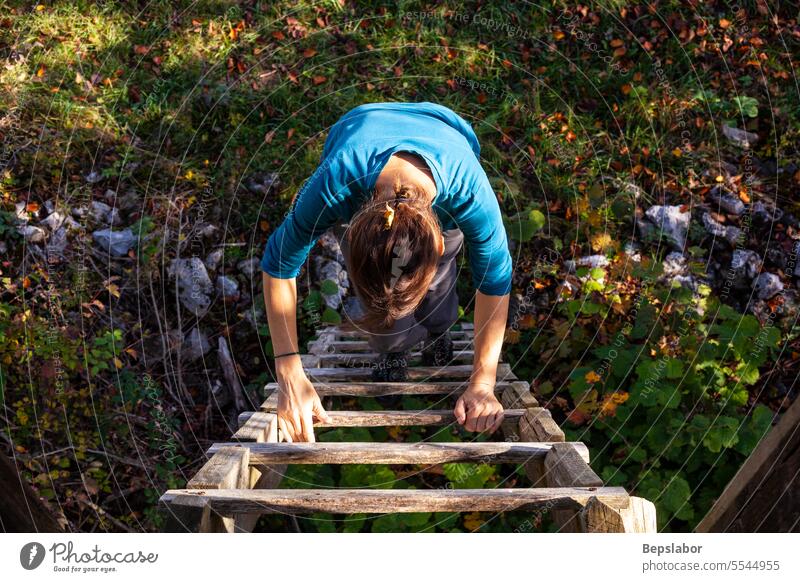 Adult woman climb up a wooden ladder photography color image adult wood - material one person people one woman only only women mid adult outdoors forest