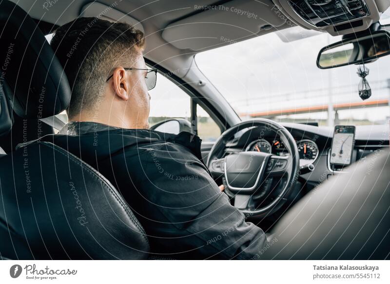 A man drives a car using a navigation application installed on a smartphone uses navigator mobile phone driving GPS using phone driver global positioning system