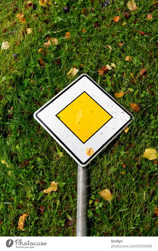 Right of way sign lliegend on a meadow Yield sign right of way sign Grass Road sign Meadow reclining Priority Signs and labeling symbol picture Bird's-eye view