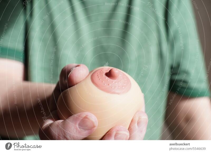 hand squeezing or groping boob shaped anti-stress ball female breast man grab fake nipple women artificial sexuality grope harassment concept inappropriate