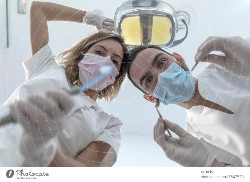 Two dentists in face masks and rubber gloves, low angle shot dentistry health care woman clinic dental doctor hospital medicine patient professional specialist