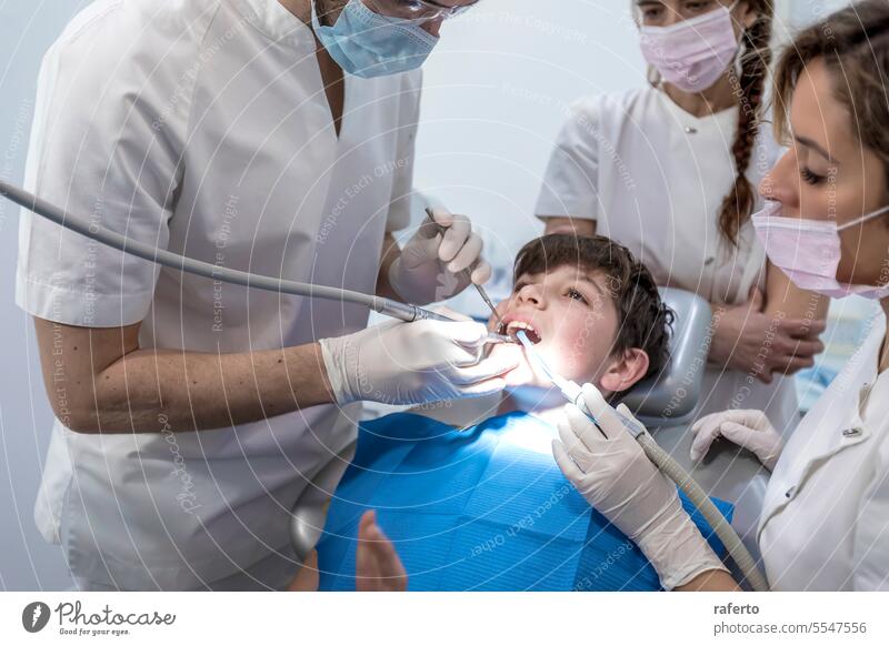 Team of dentists treating a young boy for orthodontics in the dentist's clinic medicine teeth treatment dentistry medical oral patient professional tool health