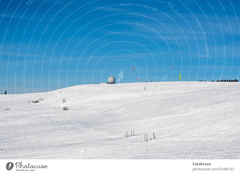 Kite surfing on the Wasserkuppe with Radome in the snow with a blue sky winter time kiting nature radar Germany day kite radome snowboard outside Motion