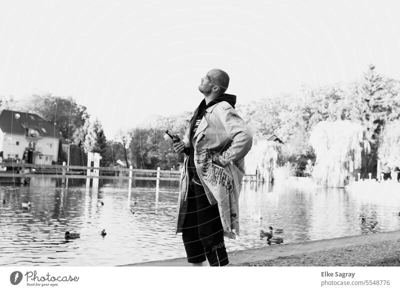 Man on the water looking at the sky black and white photo Young man Youth (Young adults) Exterior shot long coat Water 18 - 30 years Coat Lifestyle Masculine