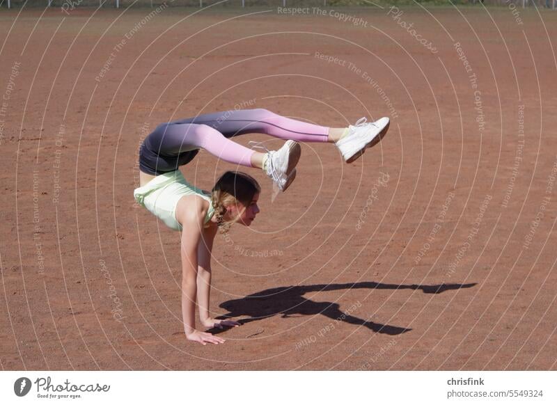 Gymnast on sports field in pose Gymnastics gymnastics bend contorsion Mobility Shadow Sporting grounds youthful Beauty & Beauty Youth (Young adults) Fitness