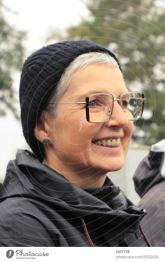Wide land |profile view of laughing woman with glasses and cap Human being Adults Woman portrait Profile view looking away Face of a woman kind Friendliness