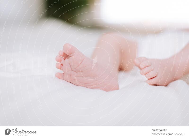 detail of the feet of a newborn in studio lighting against white baby firstborn portrait laying laying down copy space parenthood motherhood innocence life