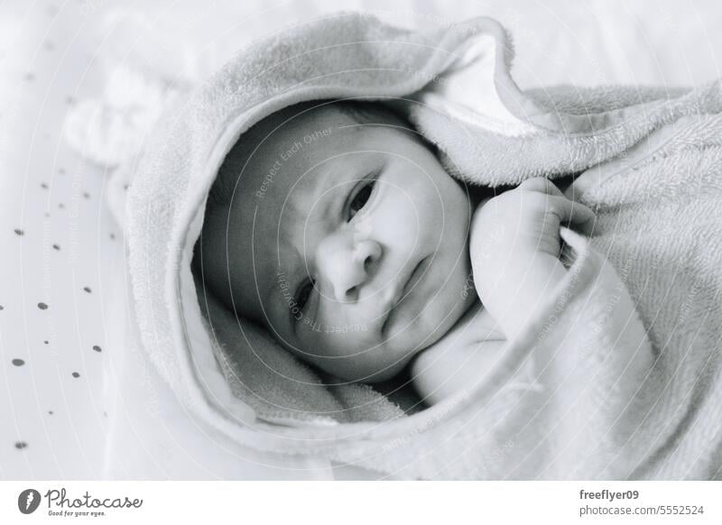 A newborn baby on a towel after his first bath ever firstborn portrait laying laying down copy space parenthood motherhood innocence life labor young boy happy