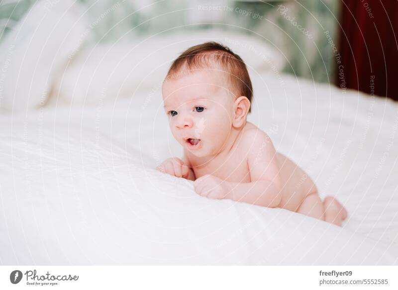newborn yawning in studio lighting against white baby firstborn portrait laying laying down copy space parenthood motherhood innocence life labor young boy