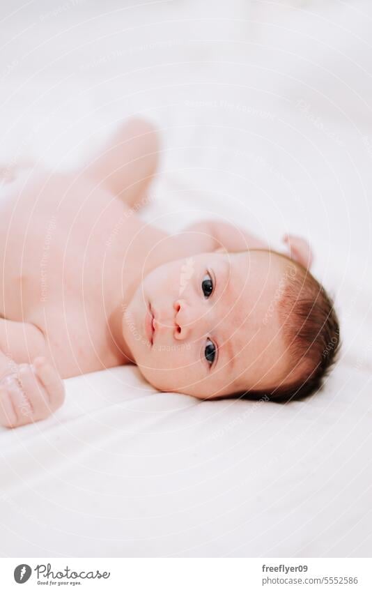 newborn in studio lighting against white baby firstborn portrait laying laying down copy space parenthood motherhood innocence life labor young boy happy small