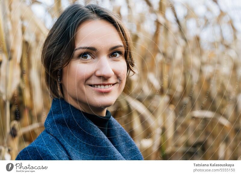 Happy smiling woman in autumn in cornfield happy coat rows fall outdoors rural countryside harvest seasonal agricultural farming nature autumnal lifestyle young