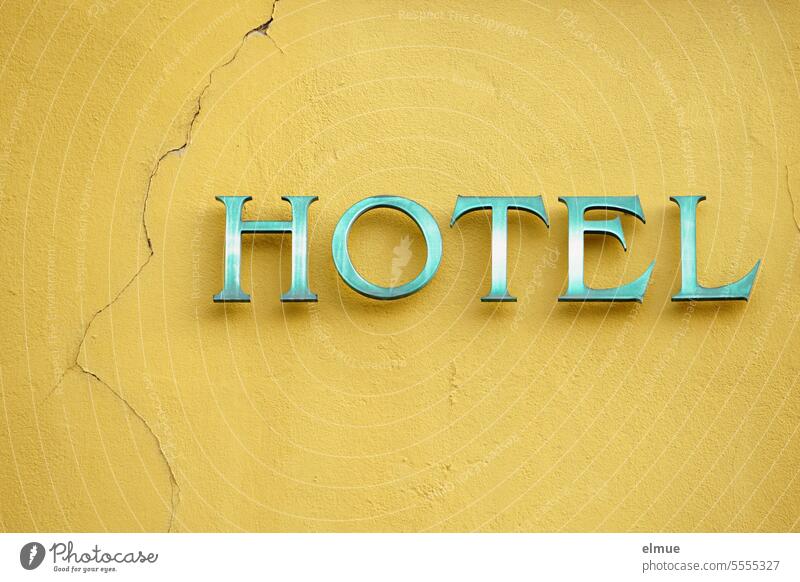 HOTEL is written in green letters on a yellow, cracked house wall Hotel overnight Accommodation Quarter spend the night Vacation & Travel Sleep