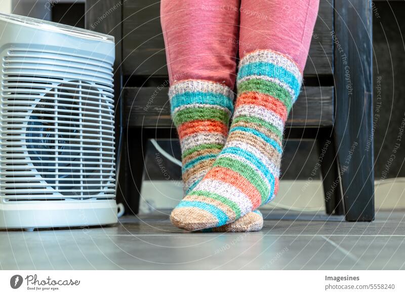 Heating period. Feet in warm knitted socks.heating with electric fan Warm period feet Electric fan more adult Equipment garments Warmth Heater Winter