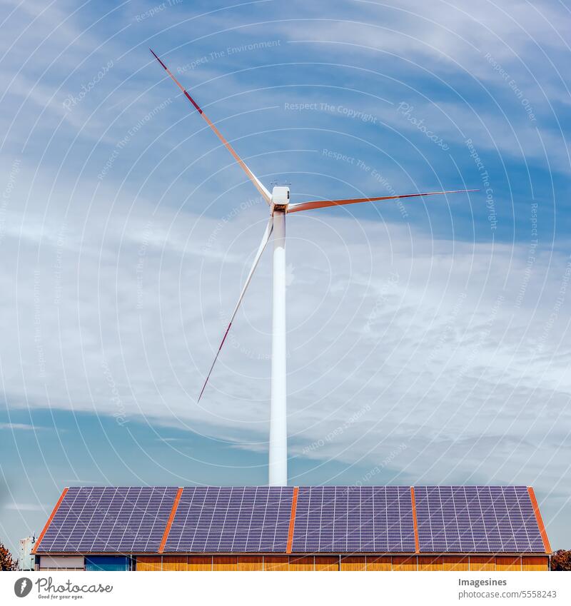 Solar panels on the roof of an industrial building and a wind turbine in a field solar collectors Roof Industrial hall Wind energy plant Field
