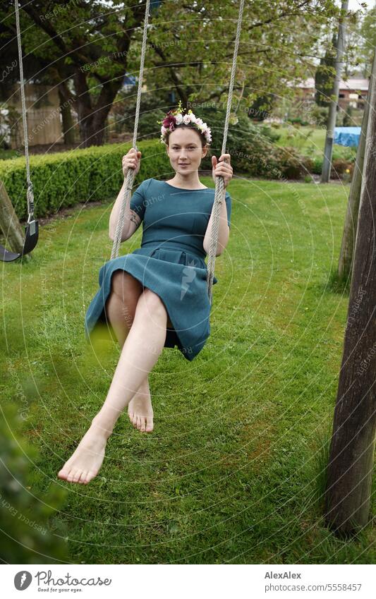 Portrait of young woman in garden on swing - barefoot with long legs and wreath of flowers in hair Woman Young woman Dress Garden Legs Barefoot Slim Athletic