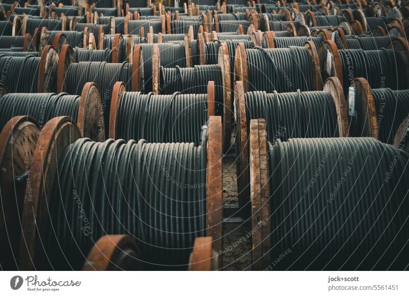 black underground cables for the power supply are wound onto wooden cable  drums - a Royalty Free Stock Photo from Photocase