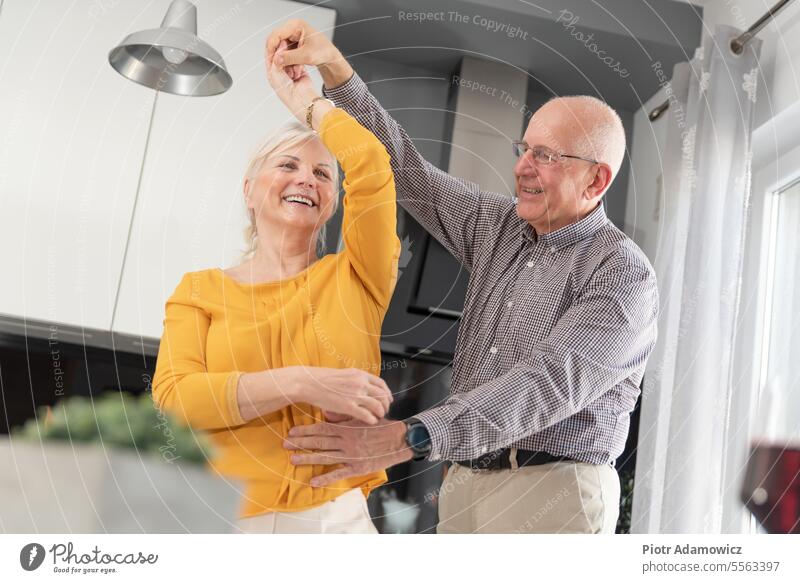 Senior couple dancing and smiling at home old people happy senior love fun dance family celebrate lifestyle woman domestic kitchen caucasian cheerful closeness