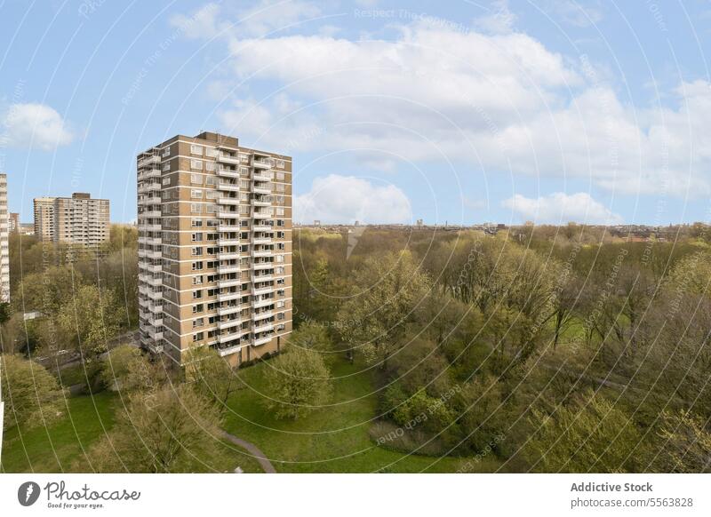 View of landscape and residential building against sky tall green area tree bush cloud nature tower exterior structure scenic aerial view grass field meadow