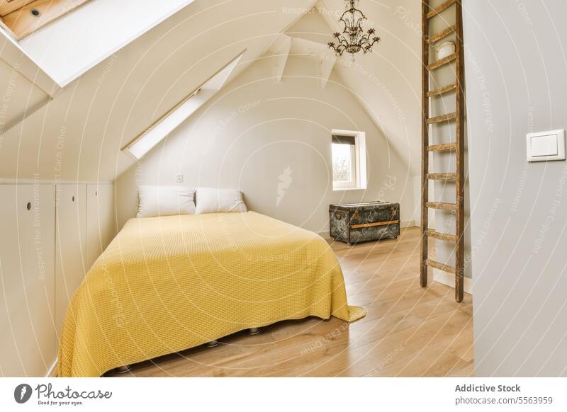 Attic bedroom with yellow bed and ladder comfortable wooden spacious white wall home pillow copy space window apartment modern interior contemporary light decor